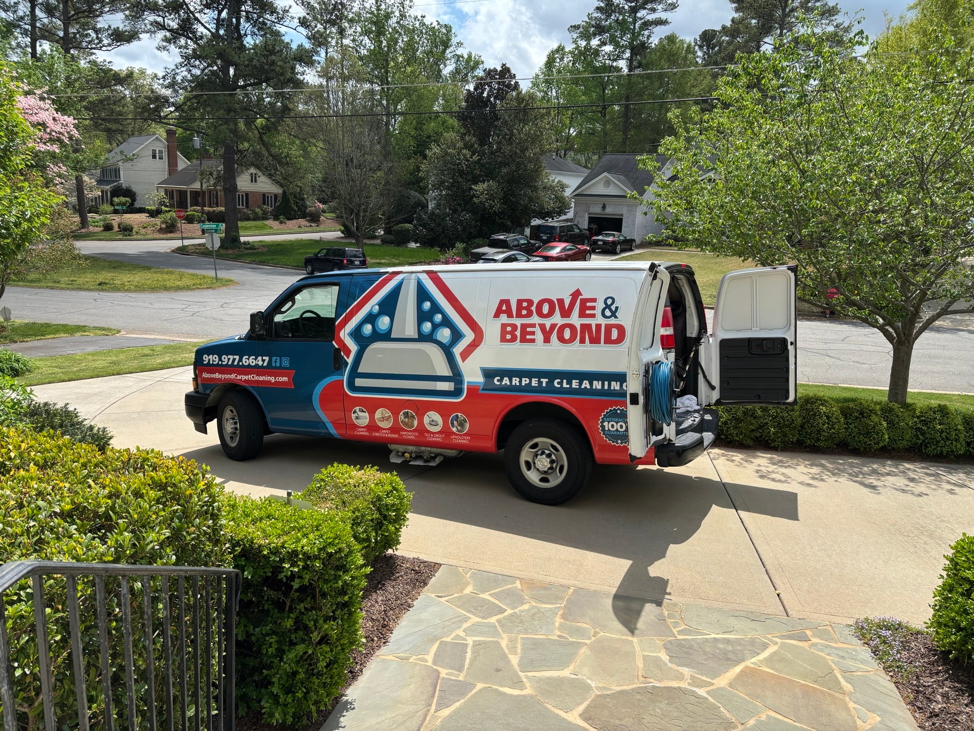 Branded service van with equipment at a residential job site